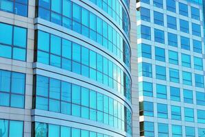 Structural glass wall reflecting blue sky. Abstract modern architecture fragment photo