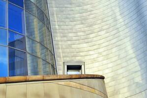 Structural glass wall reflecting blue sky. Abstract modern architecture fragment photo