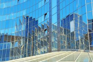 Structural glass wall reflecting blue sky. Abstract modern architecture fragment photo