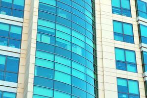 Structural glass wall reflecting blue sky. Abstract modern architecture fragment photo