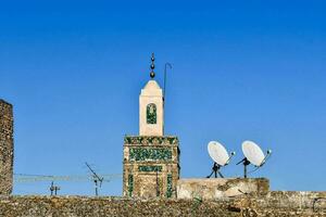 un torre con dos satélite platos en parte superior de eso foto