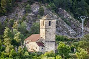 an old church sits on a hillside next to a forest photo