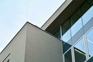 Structural glass wall reflecting blue sky. Abstract modern architecture fragment photo