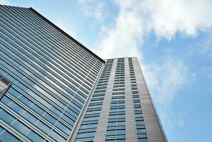 Structural glass wall reflecting blue sky. Abstract modern architecture fragment. photo