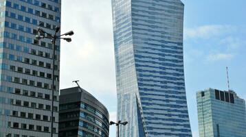 Structural glass wall reflecting blue sky. Abstract modern architecture fragment. photo