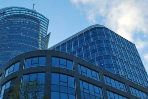 Structural glass wall reflecting blue sky. Abstract modern architecture fragment. photo