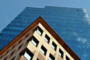 Structural glass wall reflecting blue sky. Abstract modern architecture fragment. photo