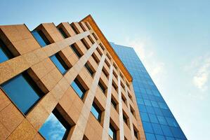 Structural glass wall reflecting blue sky. Abstract modern architecture fragment. photo