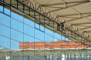 Structural glass wall reflecting blue sky. Abstract modern architecture fragment photo