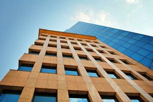 Structural glass wall reflecting blue sky. Abstract modern architecture fragment. photo