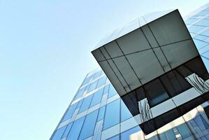 Structural glass wall reflecting blue sky. Abstract modern architecture fragment photo