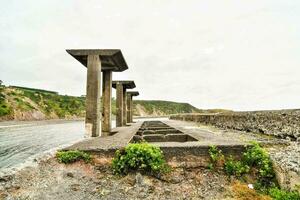 the ruins of a concrete structure on the shore photo