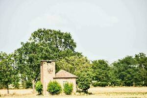 a small brick building in the middle of a field photo