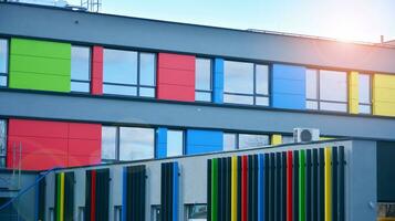 A view at a straight facade of a modern building with a dark grey facade. Dark grey metallic panel facad. Modern architectural details. photo