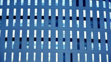 Pattern of office buildings windows illuminated at night. Glass architecture ,corporate building at night - business concept. Blue graphic filter. photo
