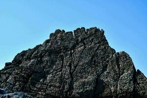 a rock formation with a blue sky in the background photo