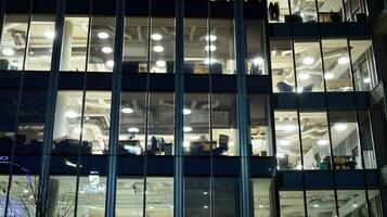 Pattern of office buildings windows illuminated at night. Glass architecture ,corporate building at night - business concept. photo
