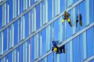 Glass building with transparent facade of the building and blue sky. Structural glass wall reflecting blue sky. Abstract modern architecture fragment. Contemporary architectural background. photo