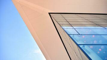 Glass building with transparent facade of the building and blue sky. Structural glass wall reflecting blue sky. Abstract modern architecture fragment. Contemporary architectural background. photo