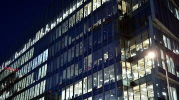 Pattern of office buildings windows illuminated at night. Glass architecture ,corporate building at night - business concept. photo