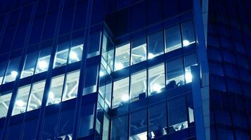Pattern of office buildings windows illuminated at night. Glass architecture ,corporate building at night - business concept. Blue graphic filter. photo