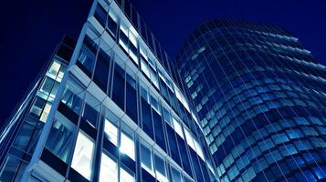 Pattern of office buildings windows illuminated at night. Glass architecture ,corporate building at night - business concept. Blue graphic filter. photo