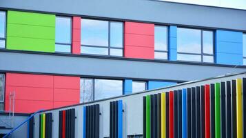 A view at a straight facade of a modern building with a dark grey facade. Dark grey metallic panel facad. Modern architectural details. photo