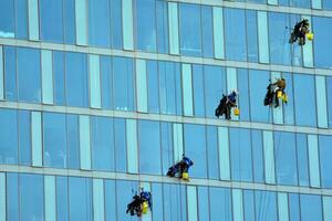 Glass building with transparent facade of the building and blue sky. Structural glass wall reflecting blue sky. Abstract modern architecture fragment. Contemporary architectural background. photo