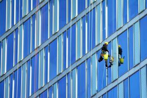 Glass building with transparent facade of the building and blue sky. Structural glass wall reflecting blue sky. Abstract modern architecture fragment. Contemporary architectural background. photo