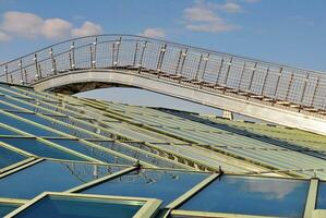 Structural glass wall reflecting blue sky. Abstract modern architecture fragment photo