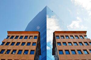 Structural glass wall reflecting blue sky. Abstract modern architecture fragment photo