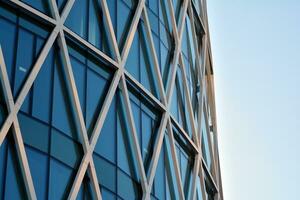 Structural glass wall reflecting blue sky. Abstract modern architecture fragment photo