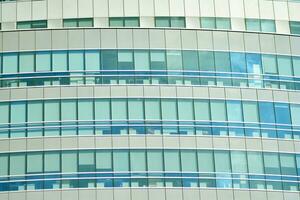 Structural glass wall reflecting blue sky. Abstract modern architecture fragment photo