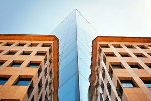 Structural glass wall reflecting blue sky. Abstract modern architecture fragment photo