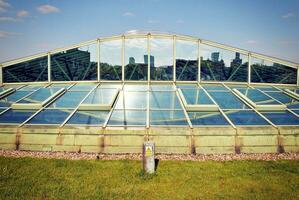 Structural glass wall reflecting blue sky. Abstract modern architecture fragment photo