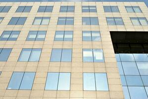 Structural glass wall reflecting blue sky. Abstract modern architecture fragment photo