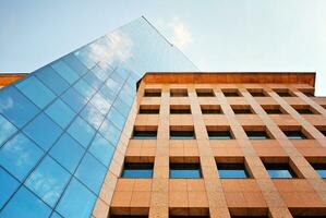 Structural glass wall reflecting blue sky. Abstract modern architecture fragment photo