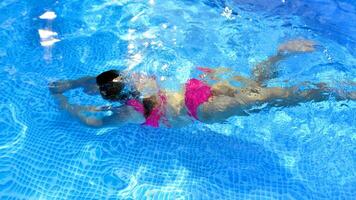 Silhouette of young woman underwater  in the pool. photo