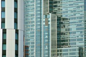 Structural glass wall reflecting blue sky. Abstract modern architecture fragment photo