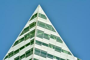 Structural glass wall reflecting blue sky. Abstract modern architecture fragment photo