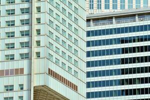 Structural glass wall reflecting blue sky. Abstract modern architecture fragment photo