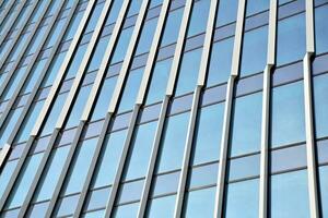 Structural glass wall reflecting blue sky. Abstract modern architecture fragment photo