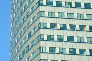 Structural glass wall reflecting blue sky. Abstract modern architecture fragment photo