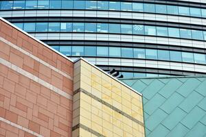 Structural glass wall reflecting blue sky. Abstract modern architecture fragment photo