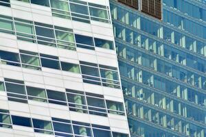 Structural glass wall reflecting blue sky. Abstract modern architecture fragment photo