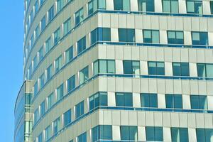 Structural glass wall reflecting blue sky. Abstract modern architecture fragment photo