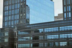 Structural glass wall reflecting blue sky. Abstract modern architecture fragment photo