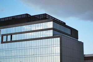 Structural glass wall reflecting blue sky. Abstract modern architecture fragment photo