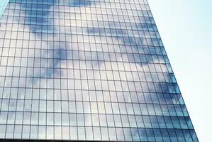 Structural glass wall reflecting blue sky. Abstract modern architecture fragment photo