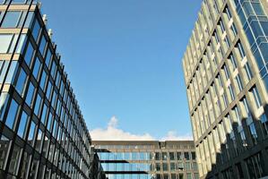 Structural glass wall reflecting blue sky. Abstract modern architecture fragment. photo